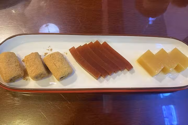 Plate of Beijing traditional sweets featuring rolled pastries and jelly slices on the Beijing Sidecar Food Tour.