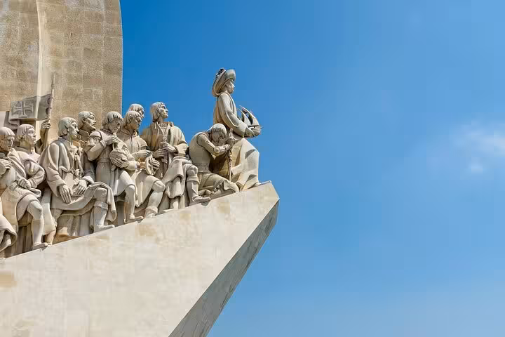 Monument to the Discoveries with explorers' statues against a clear blue sky in Belém, Lisbon.