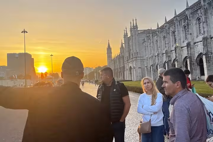 Tour group enjoying a sunset view near Jerónimos Monastery during a private tour in Belém, Lisbon.