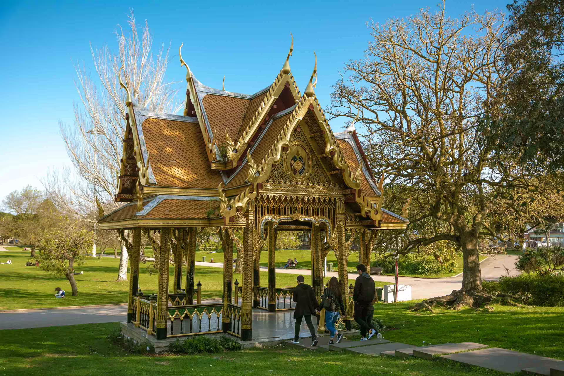 Participants explore a stunning Thai pavilion surrounded by lush greenery during a Belém sunset photography walk in Lisbon.