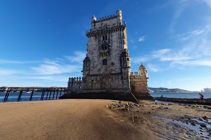 Belem Tower in Lisbon under a clear blue sky, showcasing historic architecture on the Lisboa: Old Town, New Town & Belem Tour.