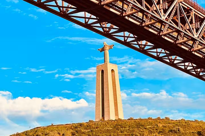 Cristo Rei statue viewed from under 25 de Abril Bridge, scenic highlight near Belém Tuk Tuk tour Lisbon