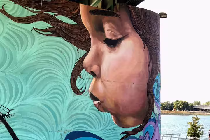 Colorful riverside mural of a woman’s profile in Belgrade, featured on a private street art walking tour