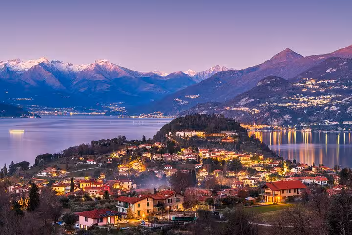 Bellagio at dusk over Lake Como with Alpine backdrop, scenic lake cruise highlight on guided tour from Milan