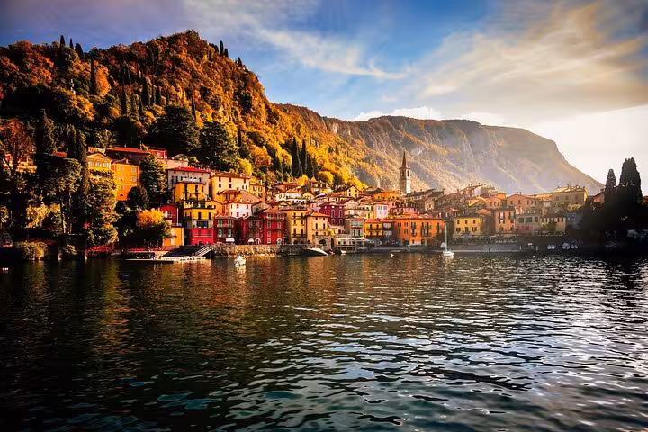 Colorful Bellagio waterfront and mountains on Lake Como cruise day tour from Milan, with autumn scenery