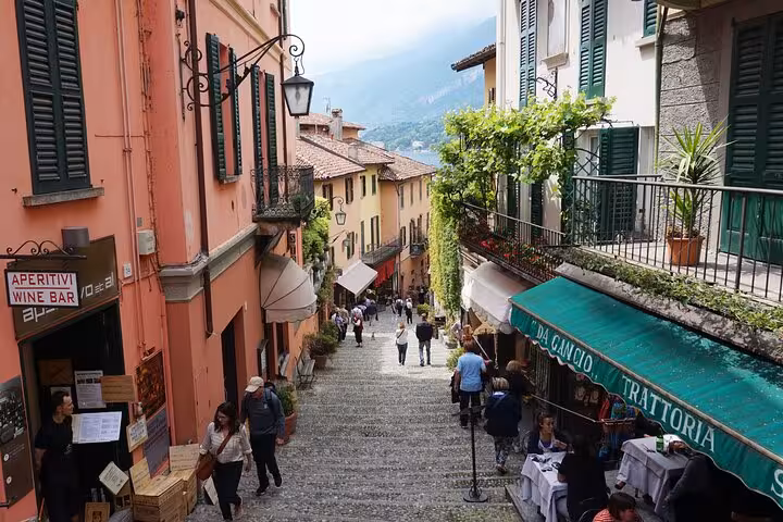 Bellagio old town steps with trattorias and shoppers, Lake Como cruise stop on guided tour from Milan