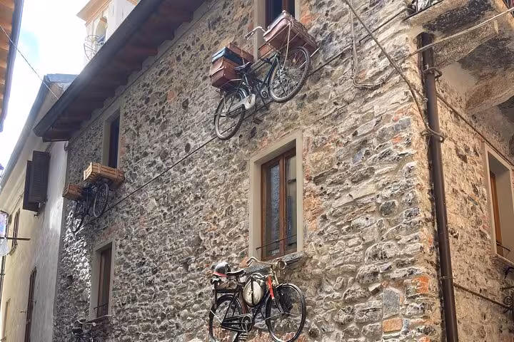 Stone alley in Bellagio, Lake Como with vintage bicycles on wall, part of guided Milan to Como tour