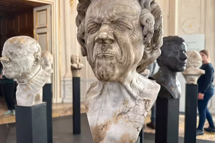 Bust sculptures displayed in a grand hall at the Belvedere, showcasing a variety of expressive facial features.