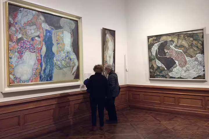 Tourists explore Gustav Klimt's masterpieces at Belvedere Museum, ideal for art enthusiasts discovering Viennese symbolism.