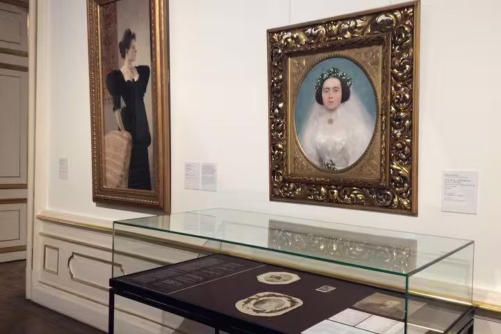Elegant portraits and historical artifacts displayed in ornate frames at the Belvedere Museum, Vienna.