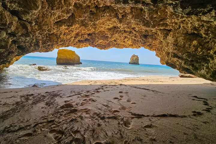 View from inside Benagil Cave showcasing sandy beach and ocean on Algarve Coast tour from Faro.