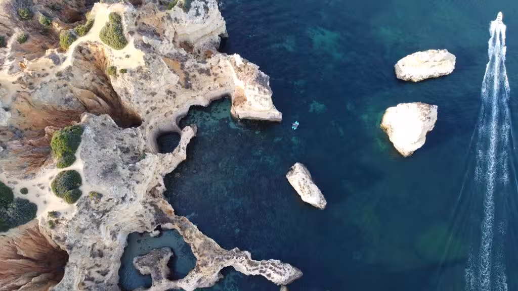 Aerial view of stunning Algarve cliffs and turquoise waters, highlighting unique landscapes on private boat tour.