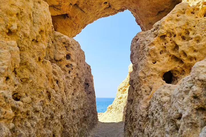 Natural rock archway framing a bright blue sky along the Algarve coast, ideal for Benagil Cave tours.