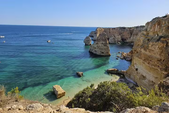 Scenic view of Algarve coast's turquoise waters and dramatic cliffs, highlighting the natural beauty of Benagil Cave Tour.