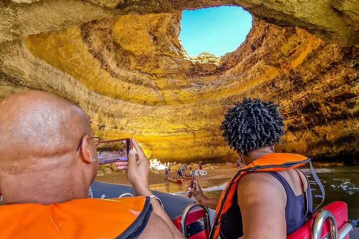 Tourists capture stunning views of Benagil Cave during a private two-day guided tour from Lisbon to the Algarve coast.