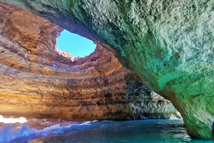 Stunning view of Algarve's Benagil Cave with sunlight illuminating the rocky interior, perfect for a private tour from Lisbon.