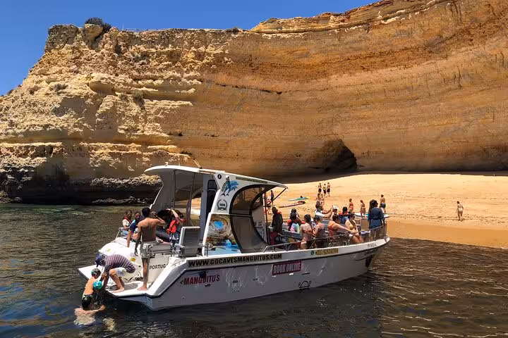 Family enjoying a boat tour near sea cliffs in Algarve