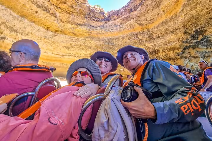 Tour guests in life jackets on boat inside Benagil Cave, Algarve highlight on private all-inclusive Lisbon tour