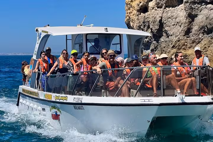 Tourists enjoying the Benagil Cave boat tour with smiling faces