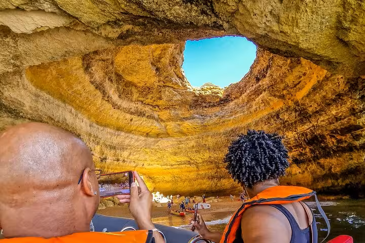 Inside Benagil Cave on Algarve private tour from Lisbon, guests in boat trip admire skylight and cliffs