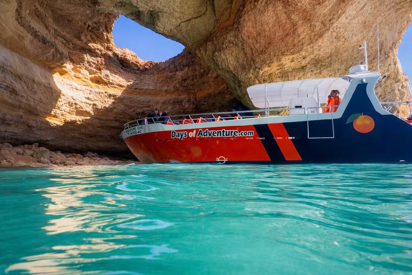 Days of Adventure boat cruising through the stunning turquoise waters of Benagil Cave on an Algarve full-day boat tour