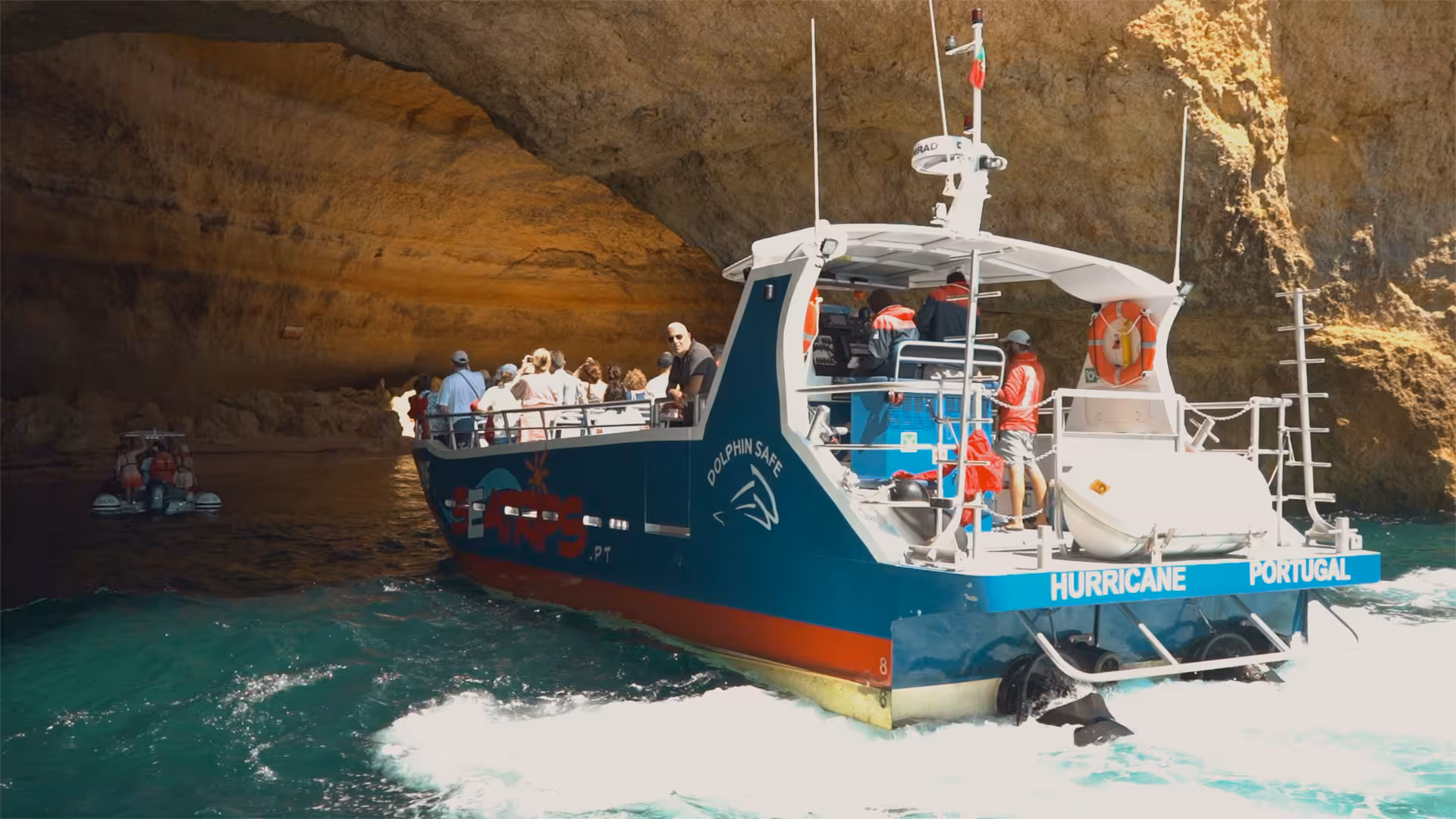 Tour boat from Lagos entering Benagil cave, guests enjoying Algarve coastline cruise and dolphin watching experience