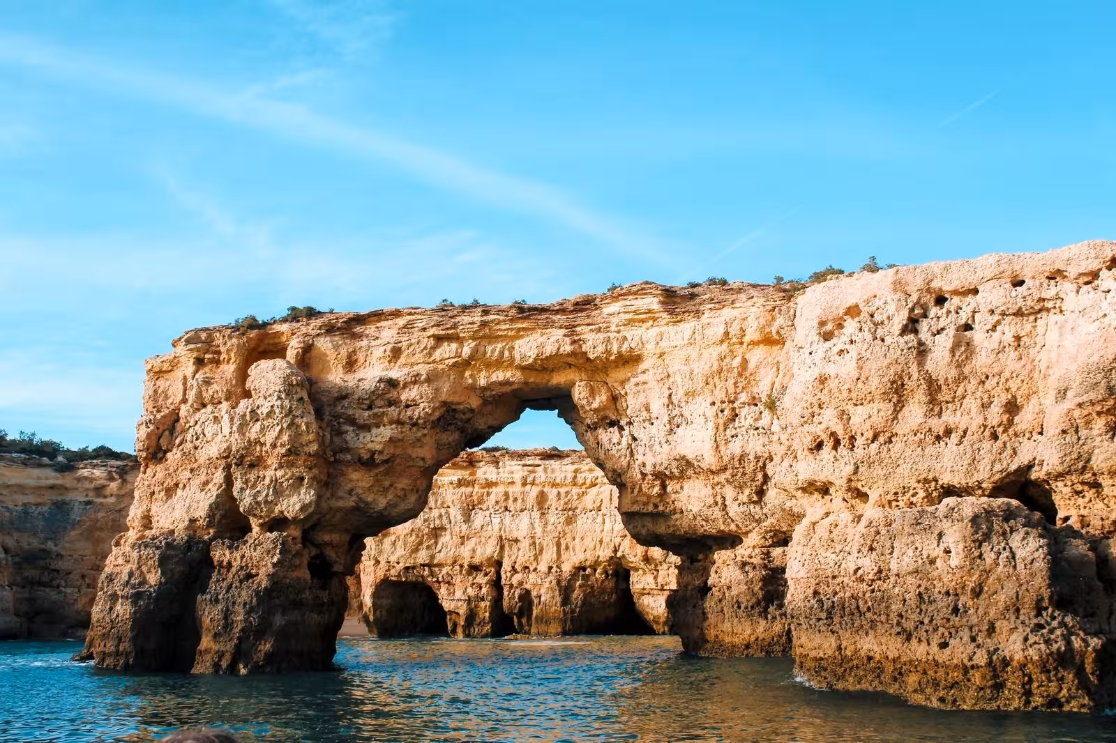 Golden rock arch and sea cliffs near Benagil Cave on a private 2-hour Algarve coastline and grotto boat excursion
