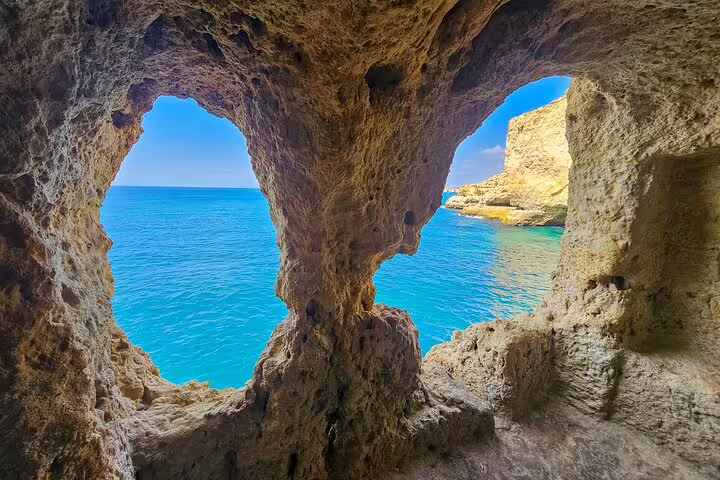 Inside view of Benagil Cave showcasing natural rock formations framing the vibrant blue Algarve coastline.