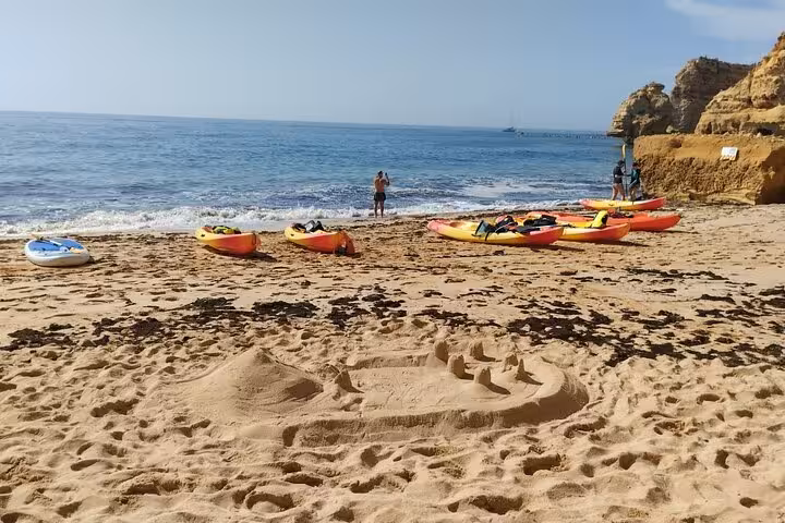 Kayaks lined up on Algarve beach before a Benagil Cave and sea caves guided kayak tour departure