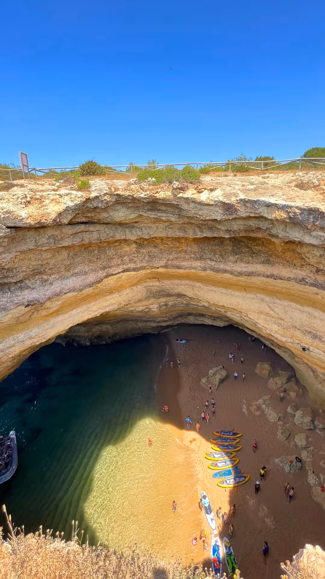 Aerial view of kayaks and sunbathers on the golden sand inside Benagil Cave along the Algarve Seven Hanging Valleys route