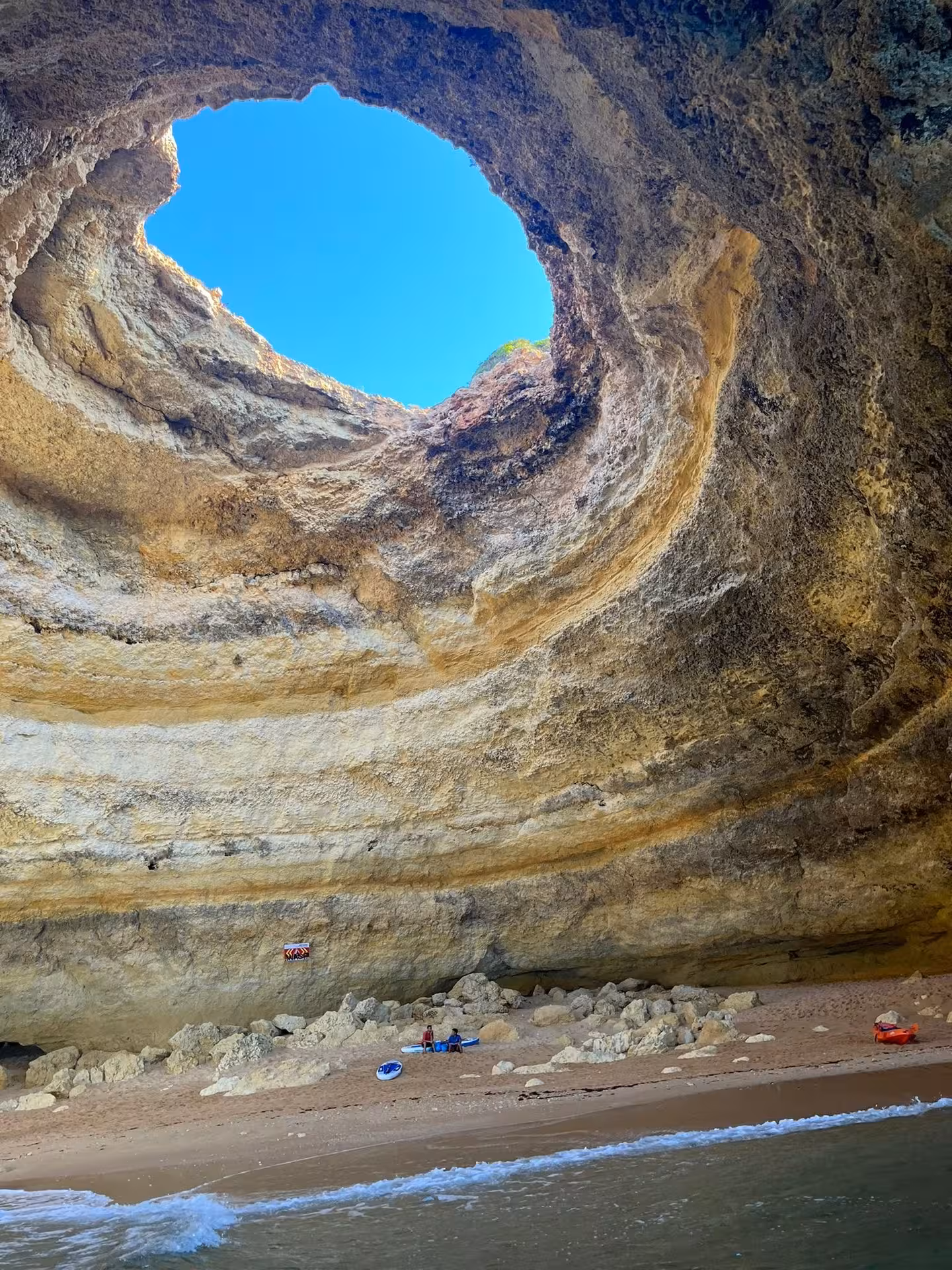 View from the sand of Benagil Cave’s sunlit skylight and towering limestone walls on an Algarve sea cave tour