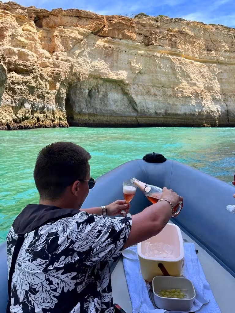 Savor a luxurious private boat tour in Algarve with champagne and snacks against breathtaking coastal limestone cliffs.