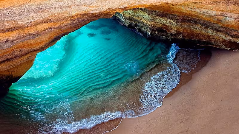 Crystal clear turquoise waters inside Benagil Cave seen from above on a private kayak tour along Algarve coastline Portugal