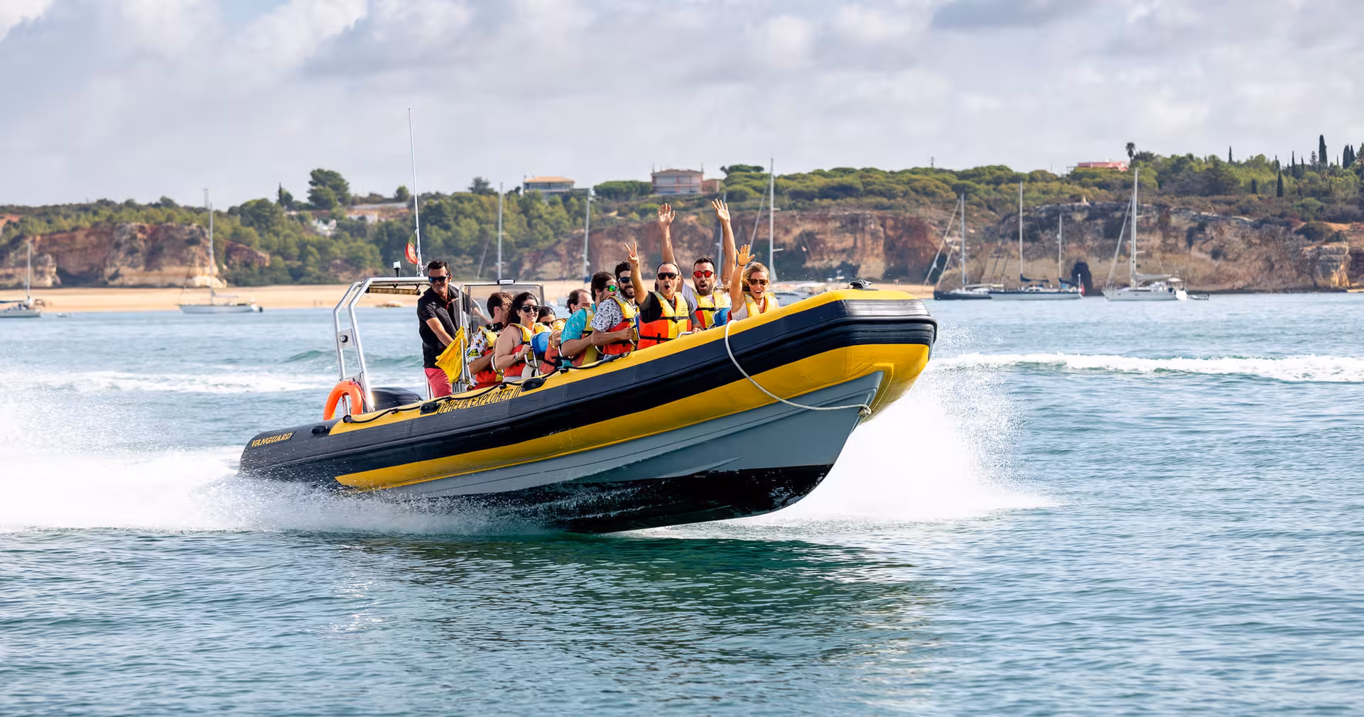 Tourists on a speedboat cruising along the Algarve coast towards the famous Benagil Cave, enjoying the adventure.