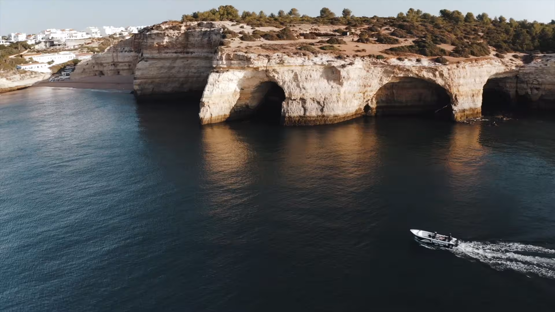Speedboat gliding past golden sea caves and cliffs on an Essential Benagil Cave Tour along Portugal’s Algarve coast