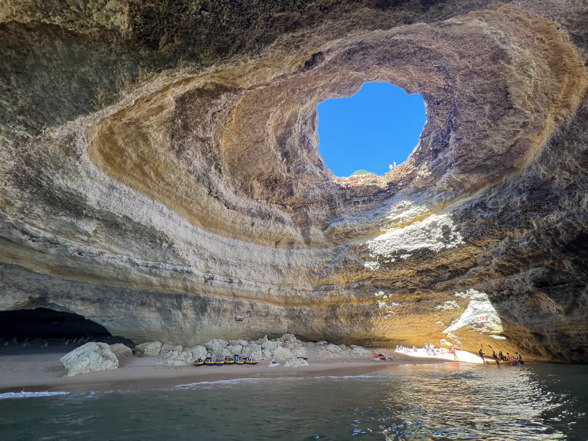 The sun illuminates the iconic Benagil Cave's skylight, revealing its beautiful natural rock formations on a morning tour.