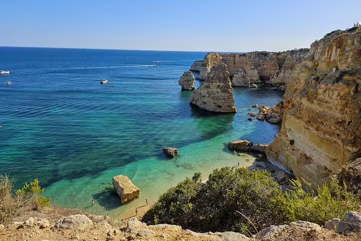 Stunning cliffside and turquoise waters of Algarve Coast on the Benagil Cave tour from Faro.