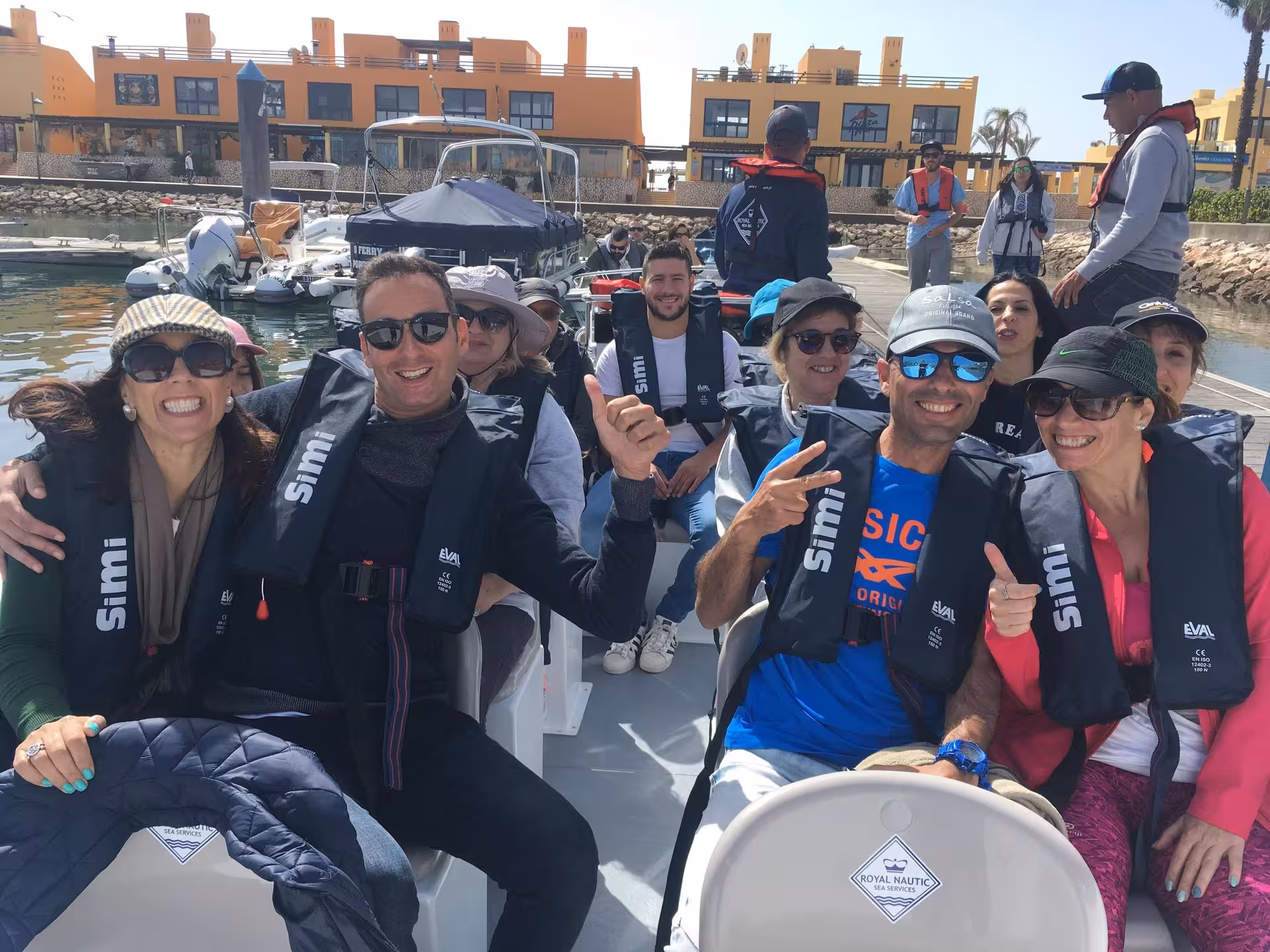 Happy group wearing life jackets on speedboat before Benagil Cave tour, departing from Algarve marina under sunny sky