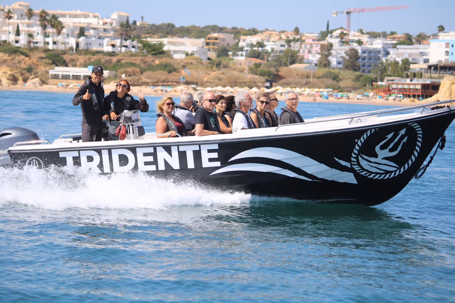 Happy passengers on a fast Tridente speedboat during an Essential Benagil Cave sightseeing tour along the Algarve coast