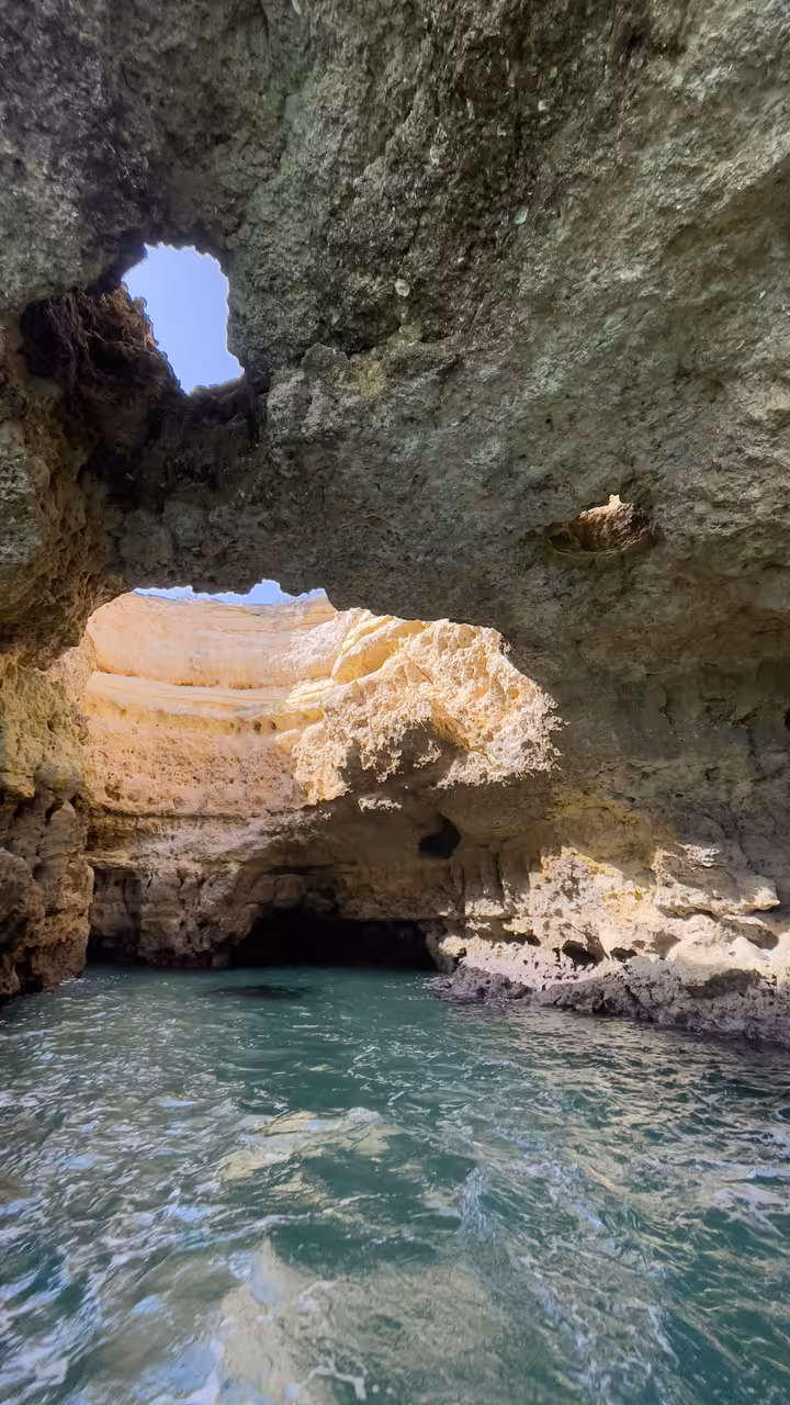 Turquoise water inside an Algarve sea cave with natural arches on a Benagil caves and coastline cruise