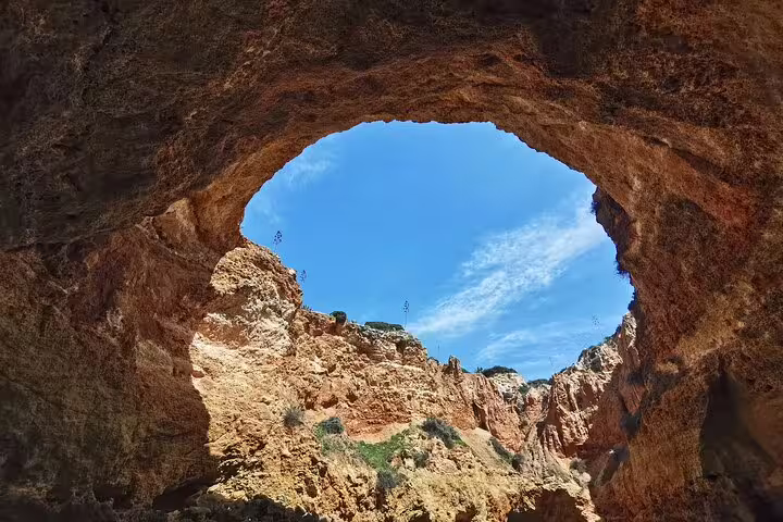 View of the stunning Benagil Caves with clear blue skies, featured in our Algarve private tour from Lisbon boat trip.