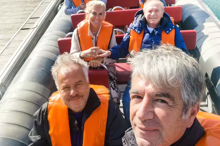 Group enjoying a scenic boat trip to Benagil caves during a private tour from Comporta to Algarve, wearing life jackets.