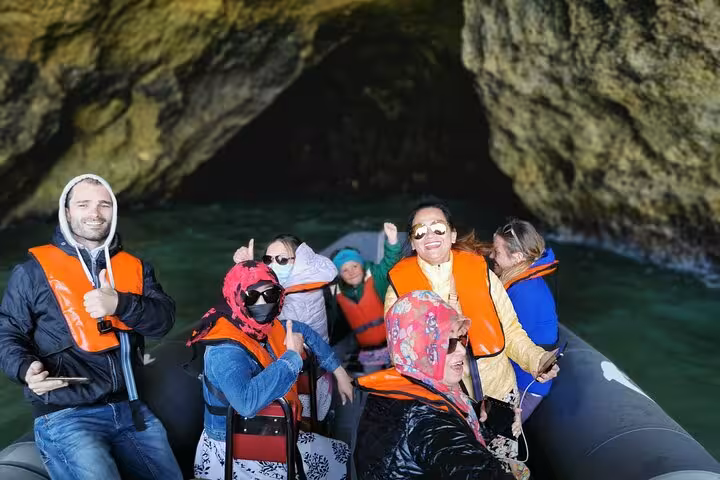 Small group in RIB boat entering Benagil sea cave, Algarve private tour day trip from Lisbon