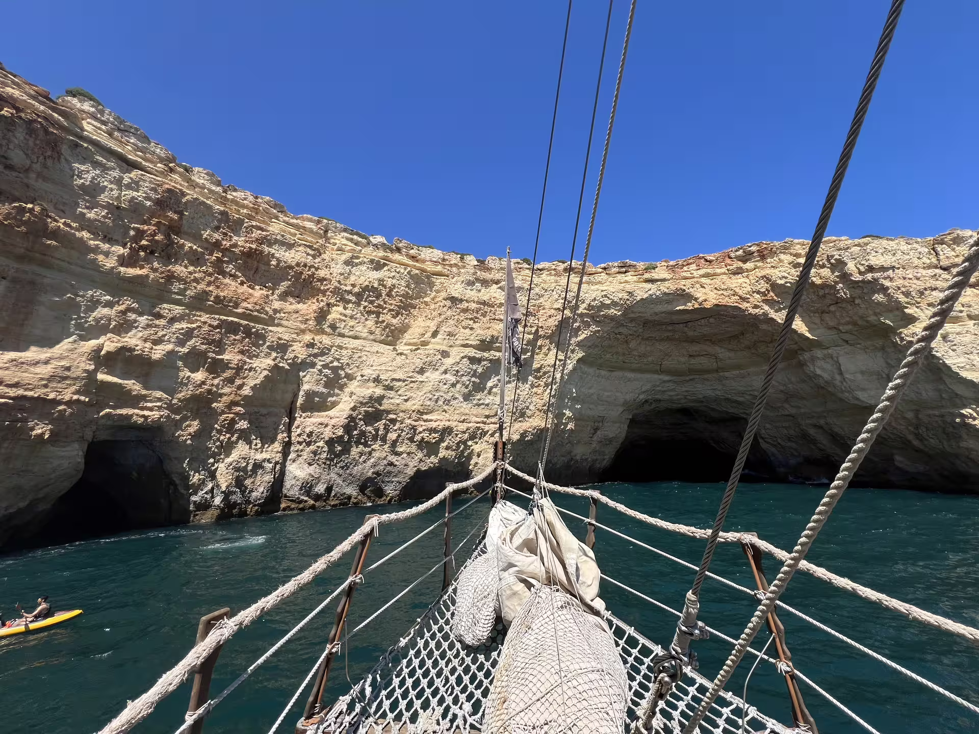 View of Benagil caves from a sailing boat on a sunny afternoon, ideal for exploring Algarve's stunning coastal formations.