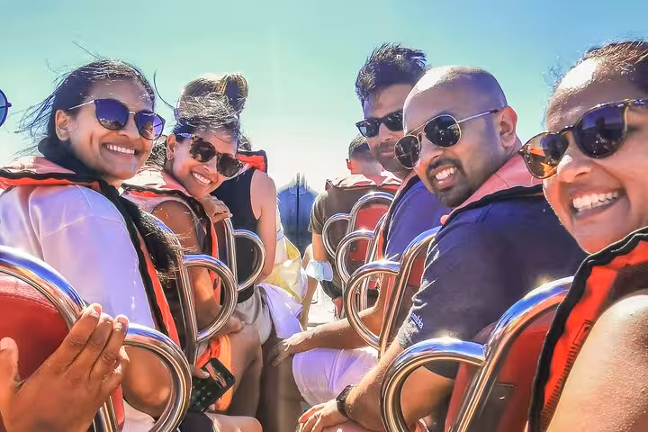 Group smiles on speedboat seats during Benagil Caves boat trip, Algarve private tour day trip from Lisbon