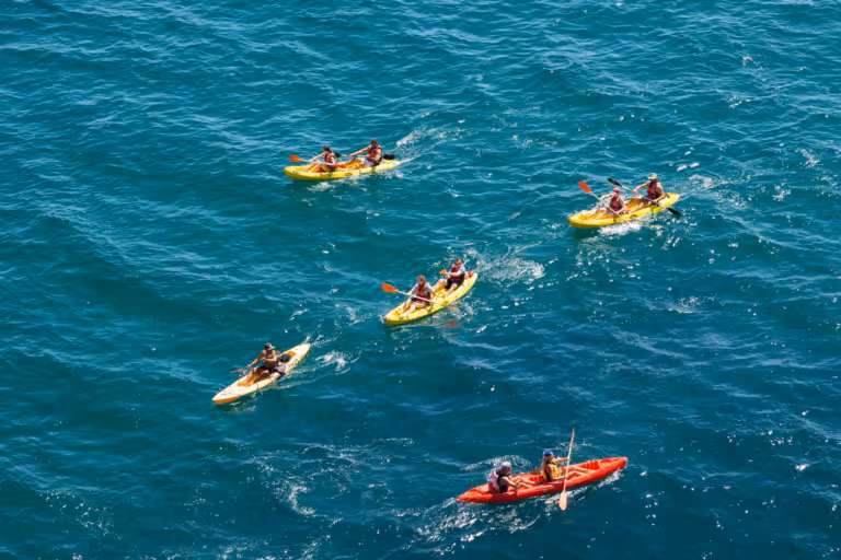 Aerial view of kayakers paddling turquoise Algarve waters on Benagil kayak rental tour to sea caves
