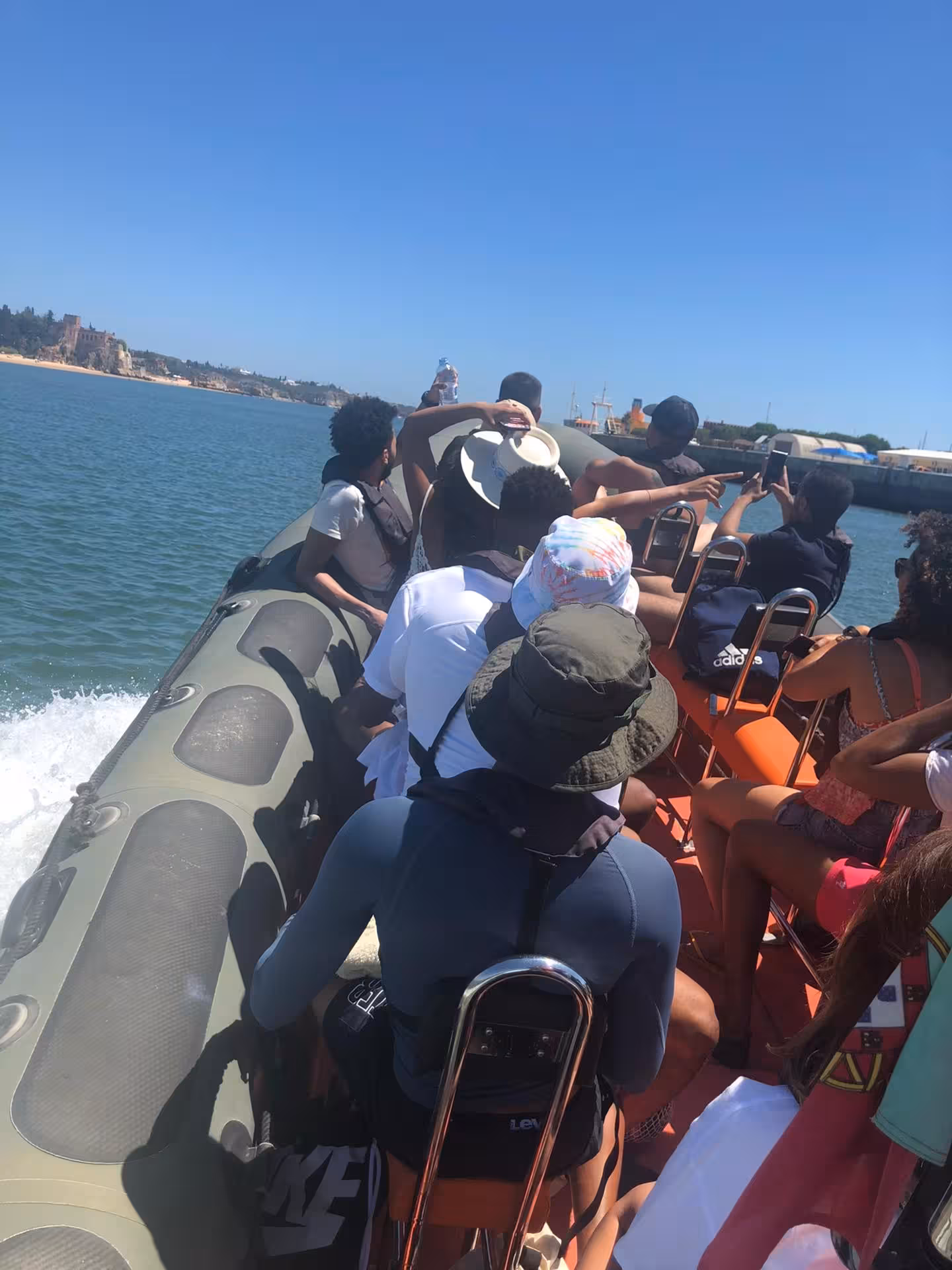 Tourists enjoying a scenic boat ride along the Algarve coast under a clear blue sky on the Benagil & Marinha Tour.