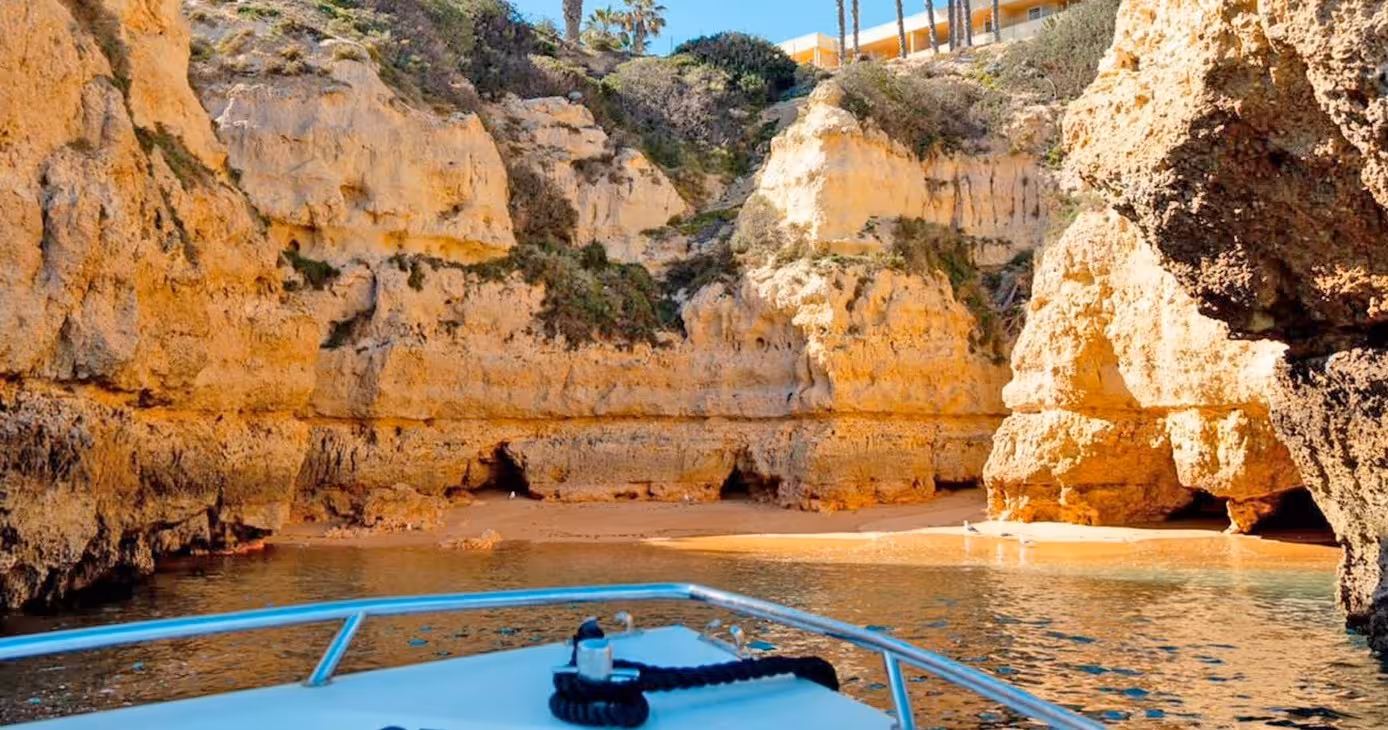 Benagil Plus 1H30 boat tour gliding past golden Algarve cliffs and hidden sandy cove on a sunny Portugal coast day