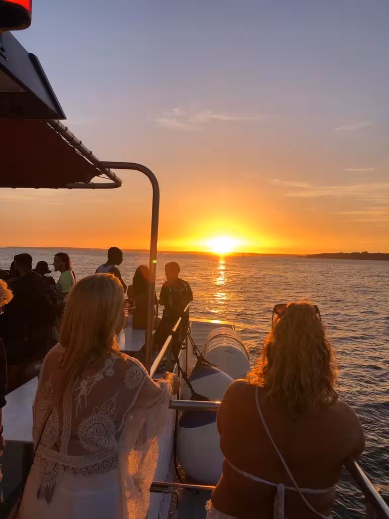 Tourists enjoy a stunning sunset view from the deck of Benagil Sunset Ophelia catamaran tour.