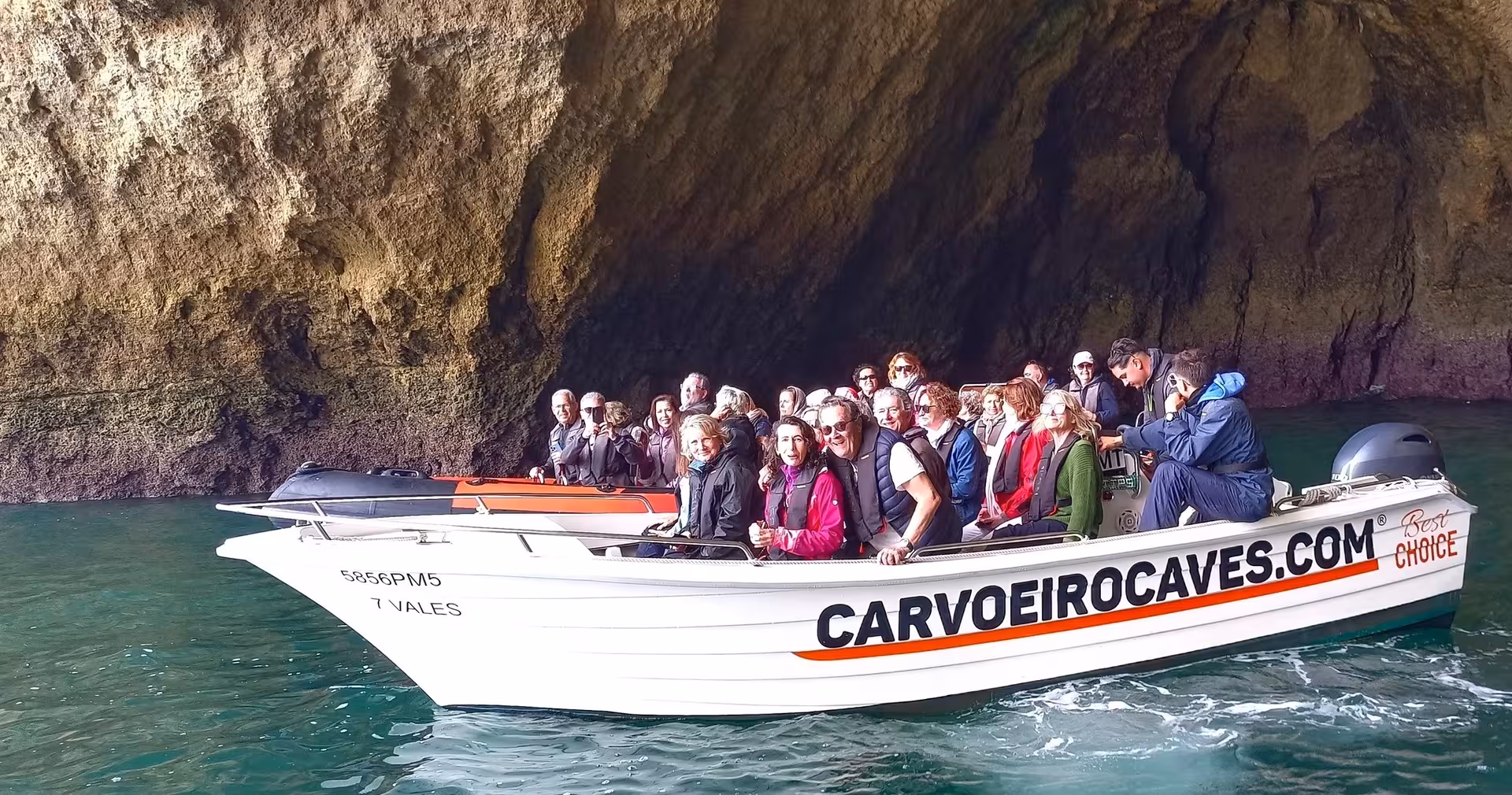 Visitors on a boat explore the impressive Carvoeiro caves during a Benagil tour from Portimão.